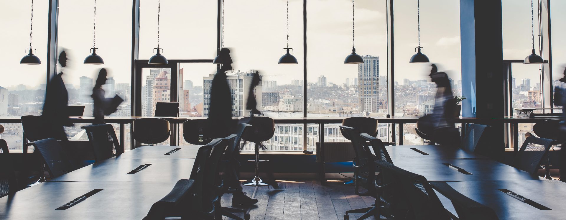 Modern office workspace with city skyline representing public liability insurance for office-based businesses