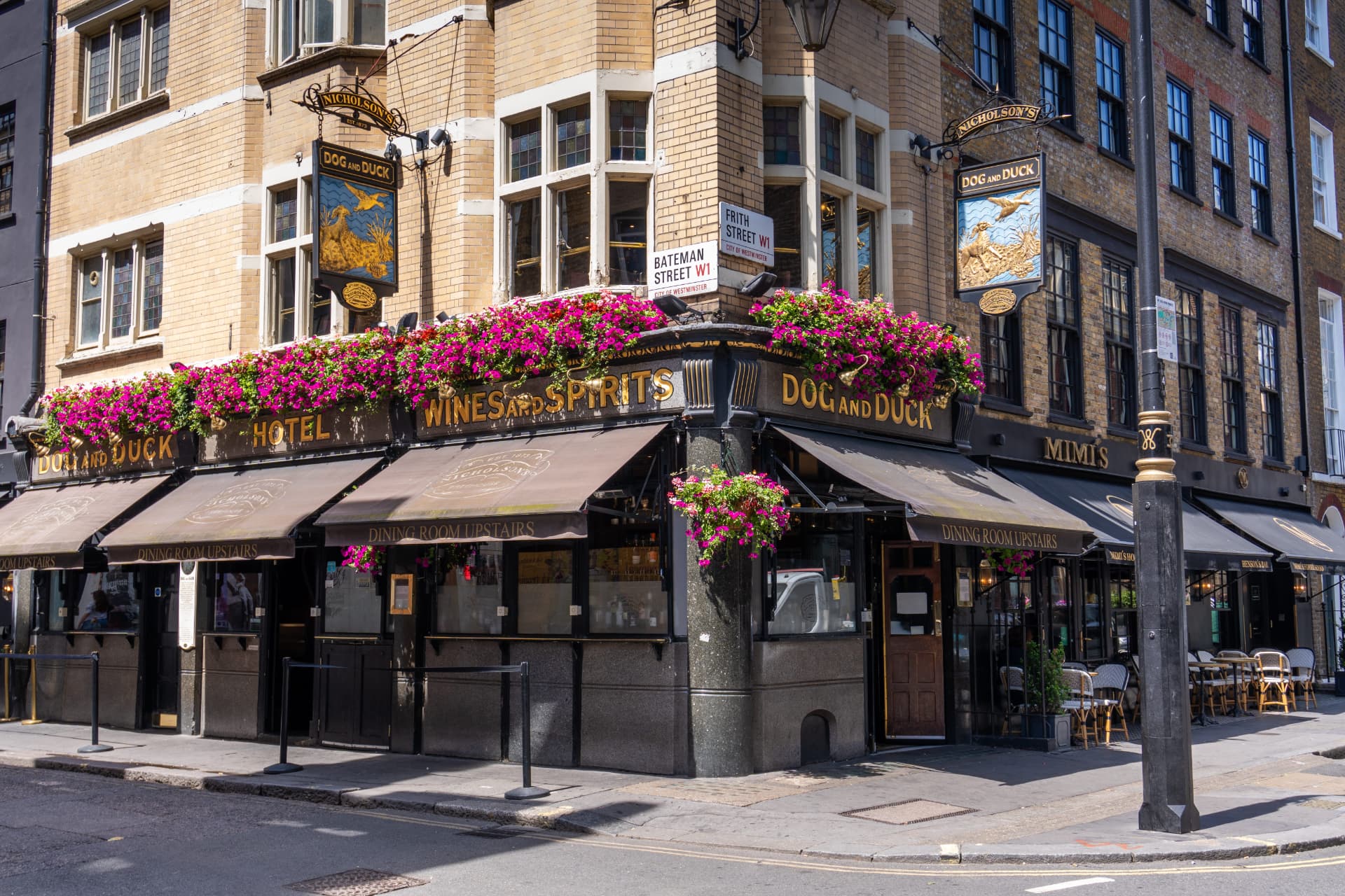 Traditional London corner pub with hanging flower baskets and outdoor seating